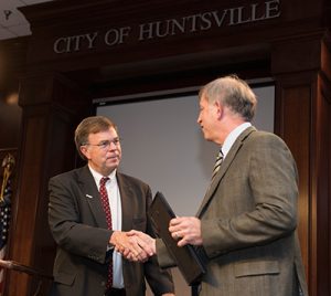 Photo of Dr. Emrich shaking hands with Mayor Battle
