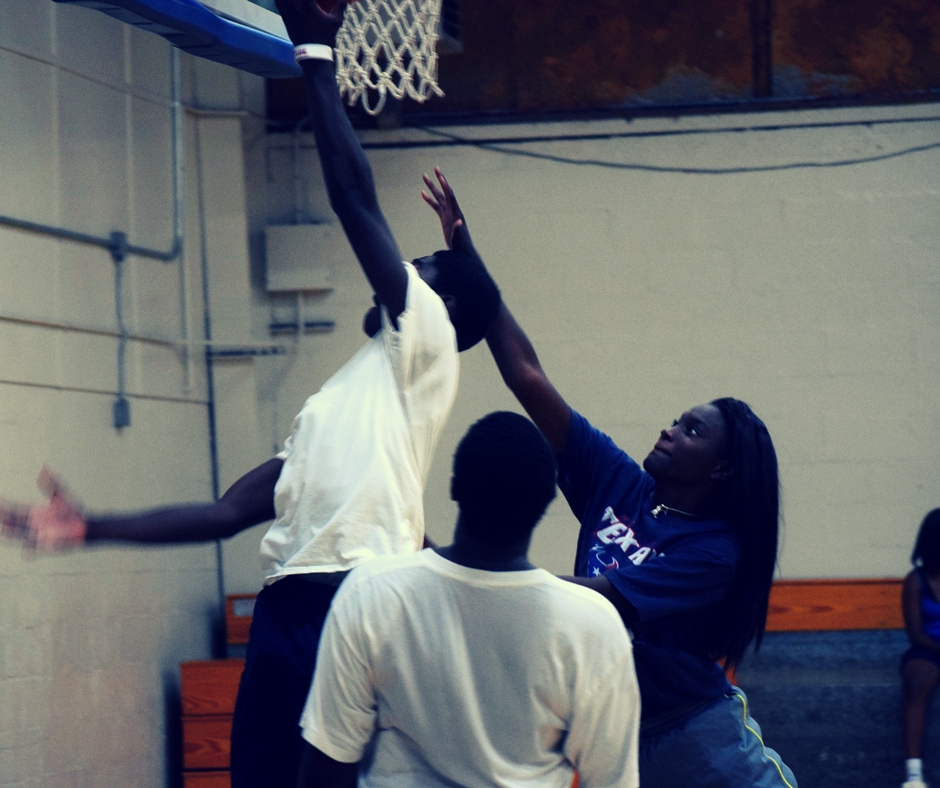 Three young teenagers playing pickup basketball.