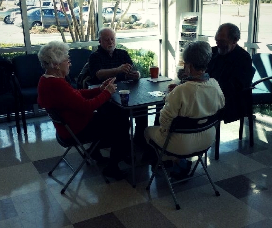 Four senior citizens playing bridge.