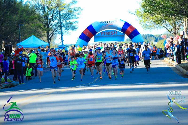 Picture of hundreds of people running through the finish line arc of the 2016 DoubleHelix Dash