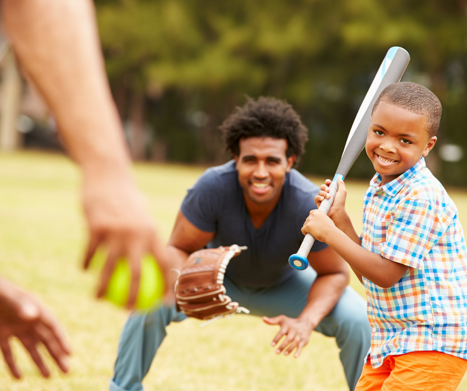 Young African American boy learning to play baseball