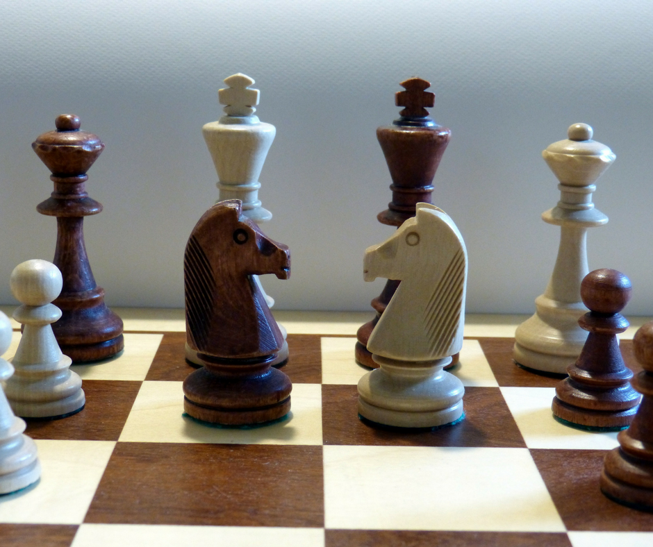 brown and white chess pieces on a board
