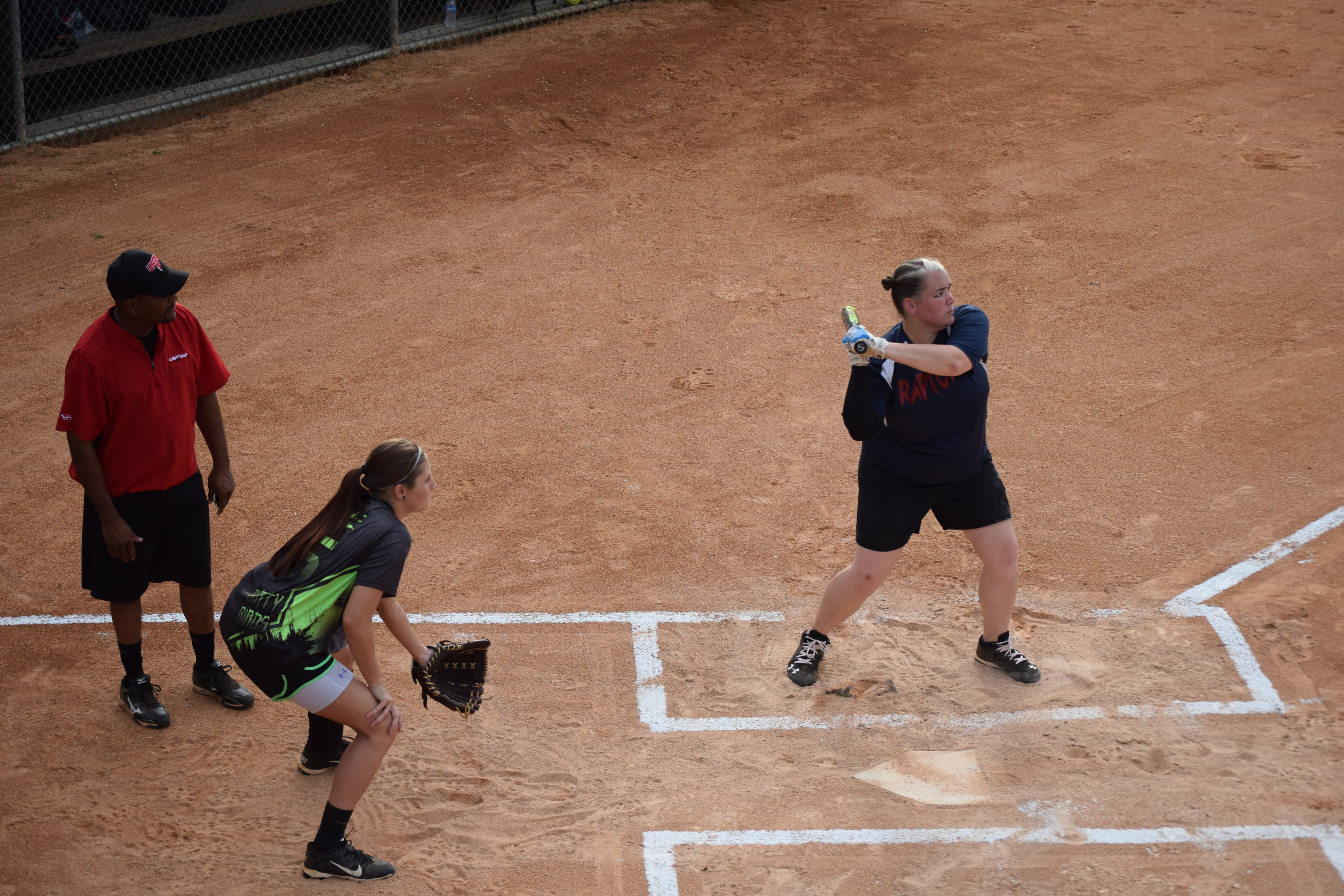 Young woman at bat, playing softball