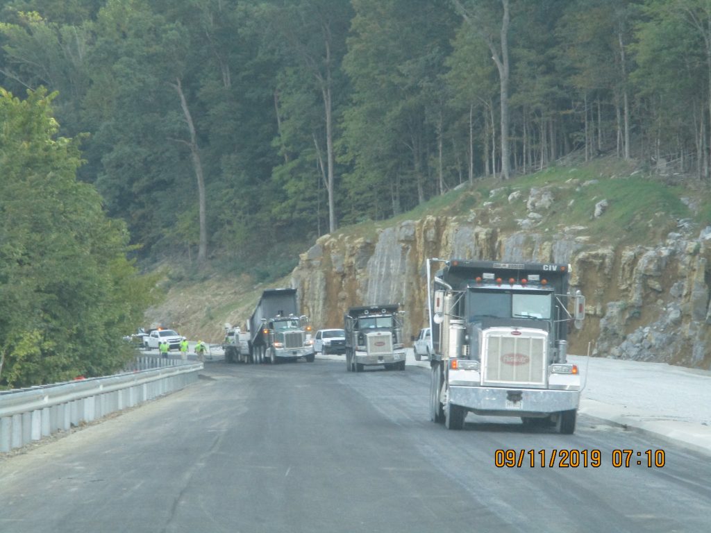 Construction trucks driving up the hill on Cecil Ashburn
