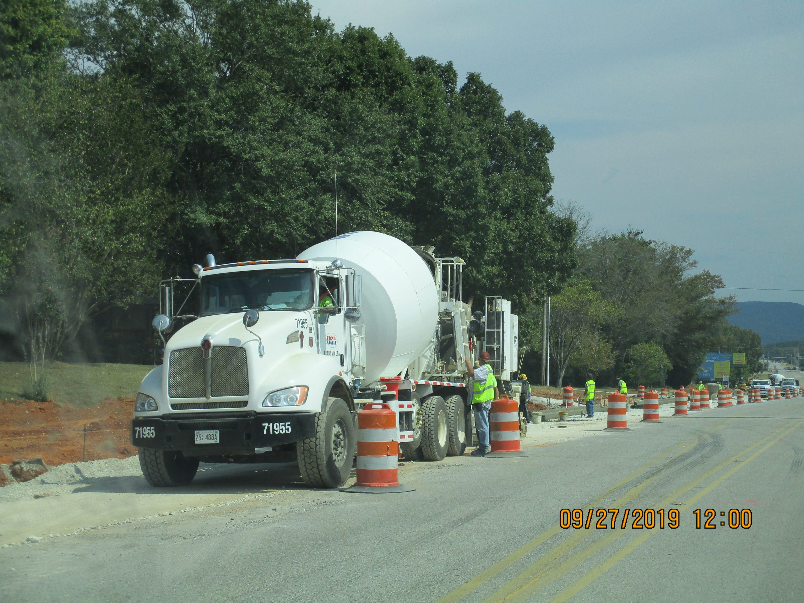 Paving with truck, cones, and construction workers on Cecil Ashburn Road