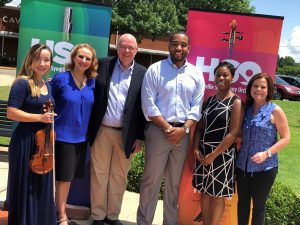 photo of Council Member Devyn Keith with symphony representatives in front of Calvary Hill School