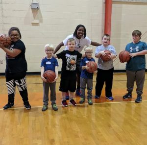 Photo of children holding basketball on basketball court