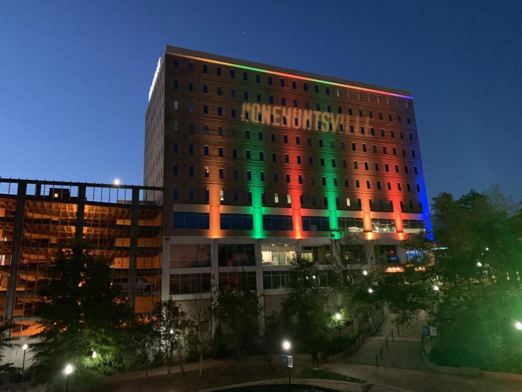 Photo of the One-Huntsville image projected onto a building at night in downtown huntsville