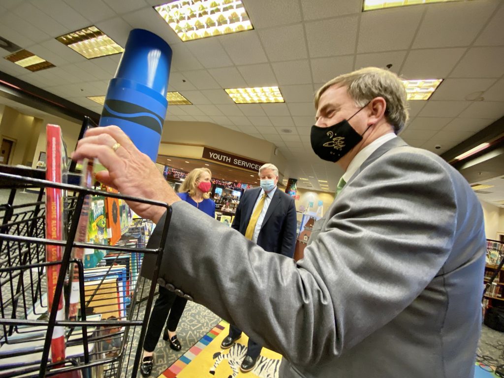 Photo of Mayor Battle looking at children's books in the library