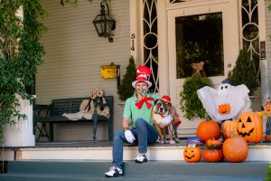 Dog and man on Halloween decorated porch