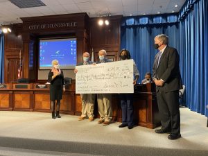 Optimist Club members present a $25,000 check to Mayor Battle at a City Council Meeting