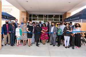 Mayor Battle, members of the Shurney Family, and library donors cut a big blue ribbon in front of the north huntsville library