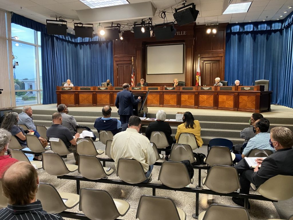 John Hamilton, city administrator, stands at the podium in the City Council chambers to deliver the City's response to the police advisory review