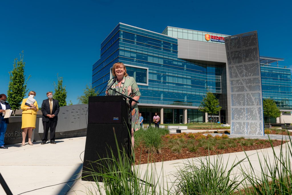 Woman speaks at podium in outdoor park