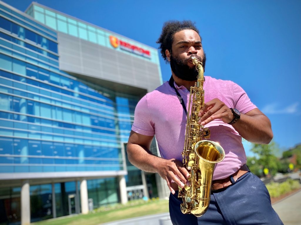 Man playing saxophone in a park.