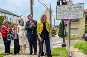 Donna Castellano, executive director of the Historic Huntsville Foundation, unveils a marker noting Huntsville’s role in the women’s suffrage movement. She is joined by Huntsville Mayor Tommy Battle, Rebekah McKinney, Janet Watson, and Marsha Weinstein. The marker is outlined in purple and reads VOTES FOR WOMEN.