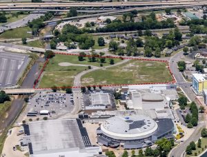 An aerial view showing the outline of a new downtown development project. The area to be developed is outlined in a red dotted line.