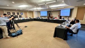 Members of the media film a joint session of the Huntsville City School Board and Huntsville City Council at the Huntsville/Madison County Chamber