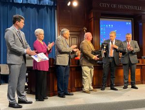 Chief McMurray standing in the Council Chambers with Council Member Akridge, Officer Hollingsworth and area stakeholders presenting a CIT Certification Gold Level Award to the public.