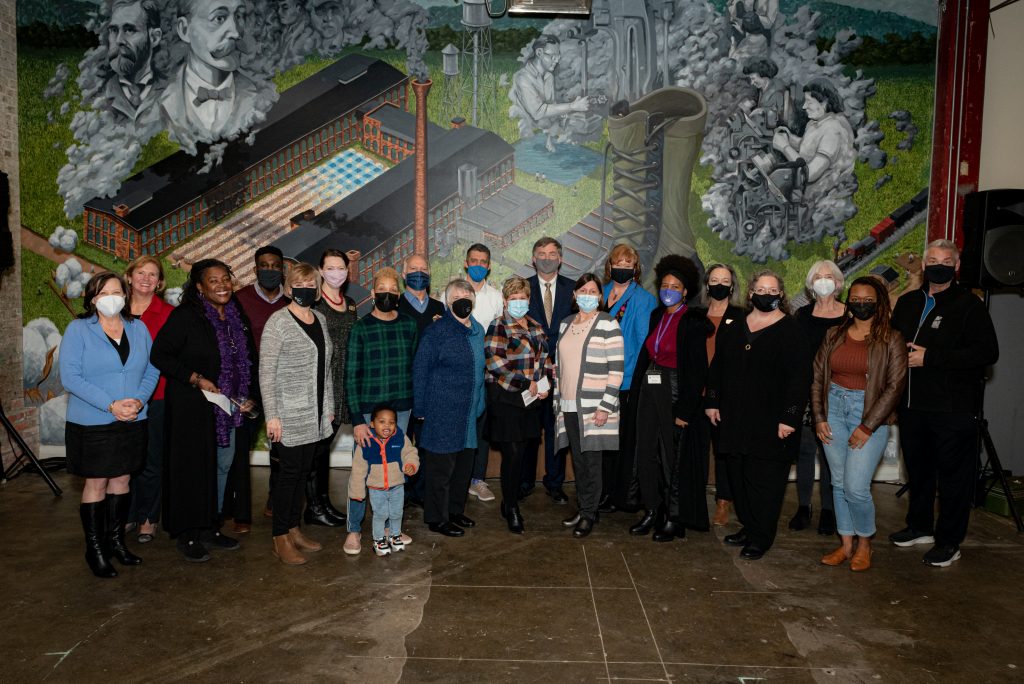 photo of Mayor Battle with Arts Huntsville award recipients in front of a mural in Lowe Mill
