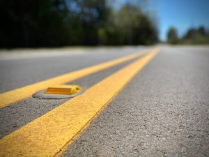 resurfacing close up of road with yellow center striping