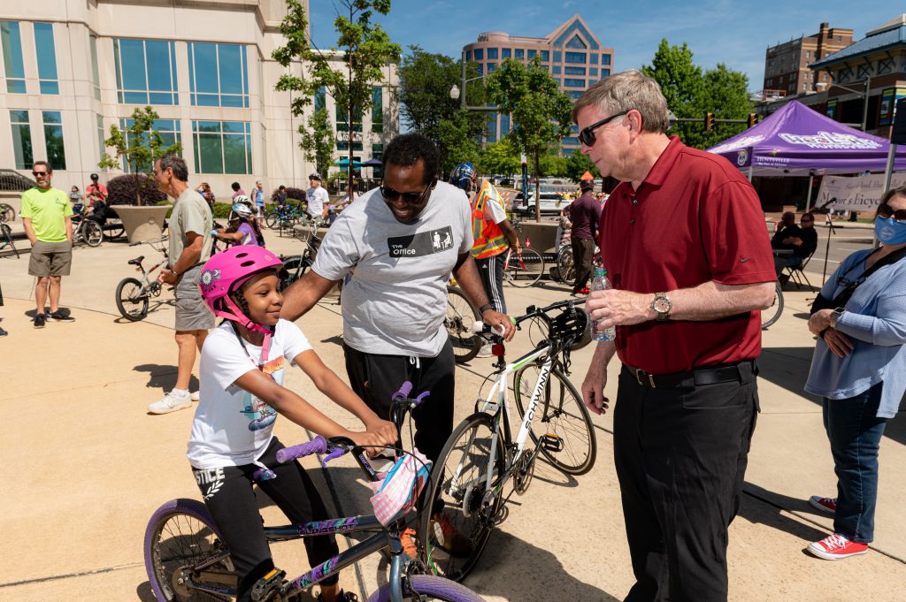 Mayor Battle greets a young girl on her bicycle before the 2021 ride