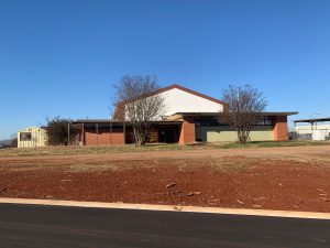 A picture of the current armory. It is brick and there is dirt all around.