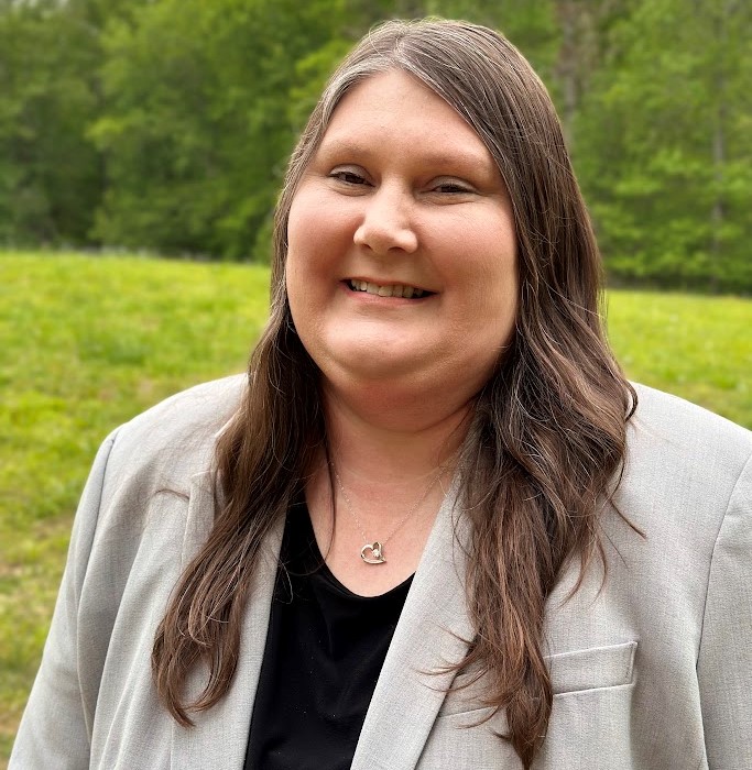 woman in beige blazer smiles for photo