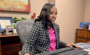 woman sitting at her desk typing on a computer