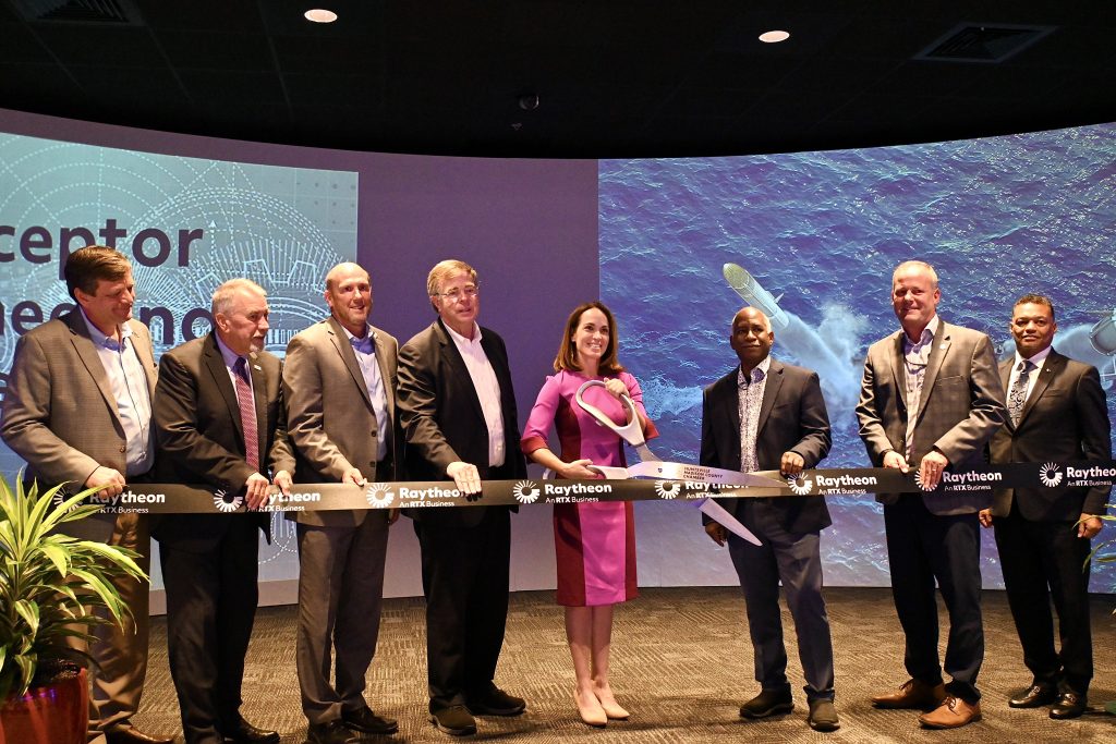 adult men and woman stand for ribbon cutting