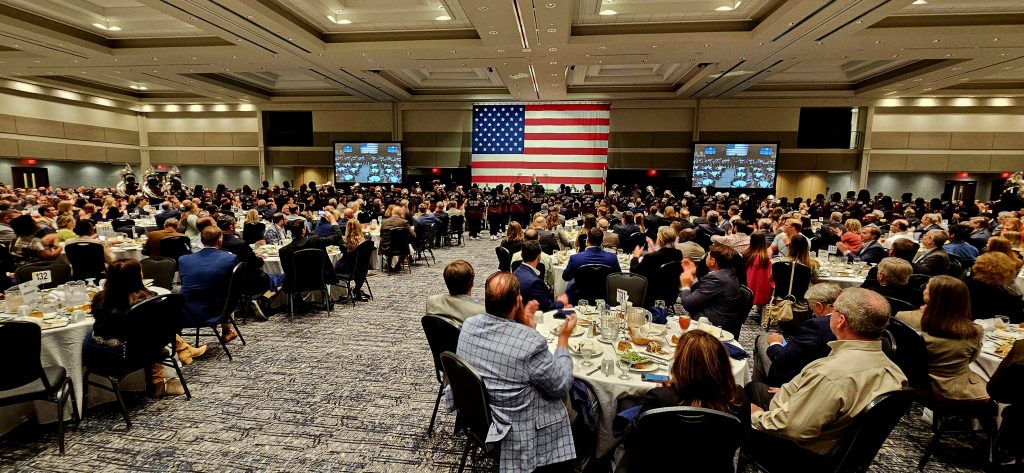 Large group of leaders sits in chairs at luncheon for State of the City