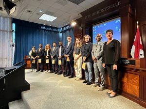 group of adult men, women and teenagers stand in line for photo