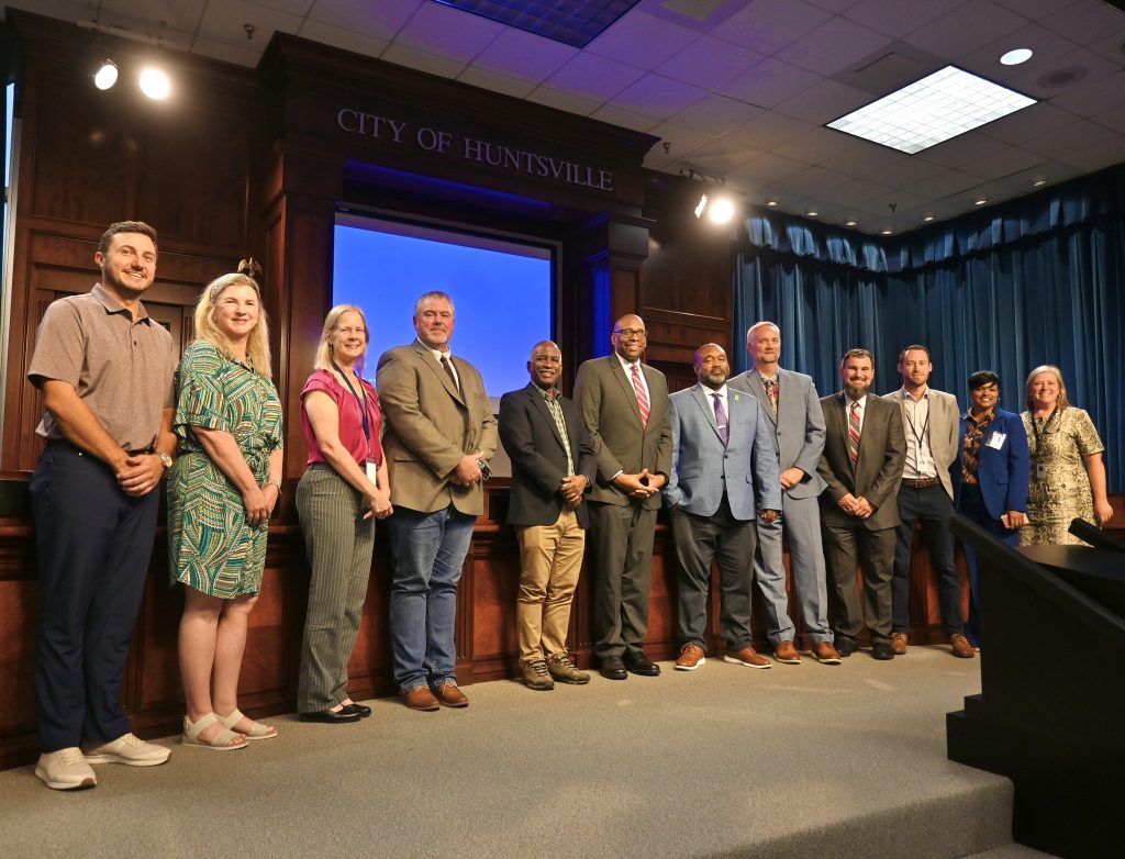 group of adult men and women stand in line for photo