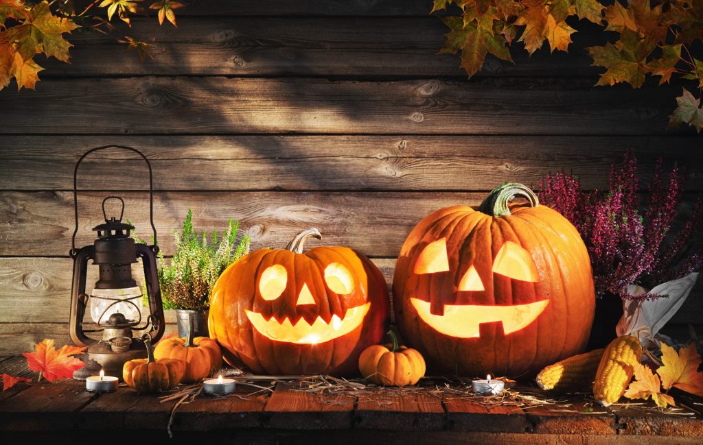 Smiling jack-o-lanterns lit up with candle inside