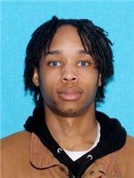 Man wanted for capital murder drivers license photo on blue background with brown hoodie 