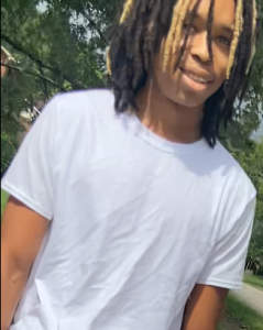 Man wanted for capital murder with long hair looking at camera with white t-shirt