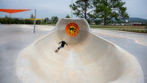 Man wearing helmet skateboards at new skatepark