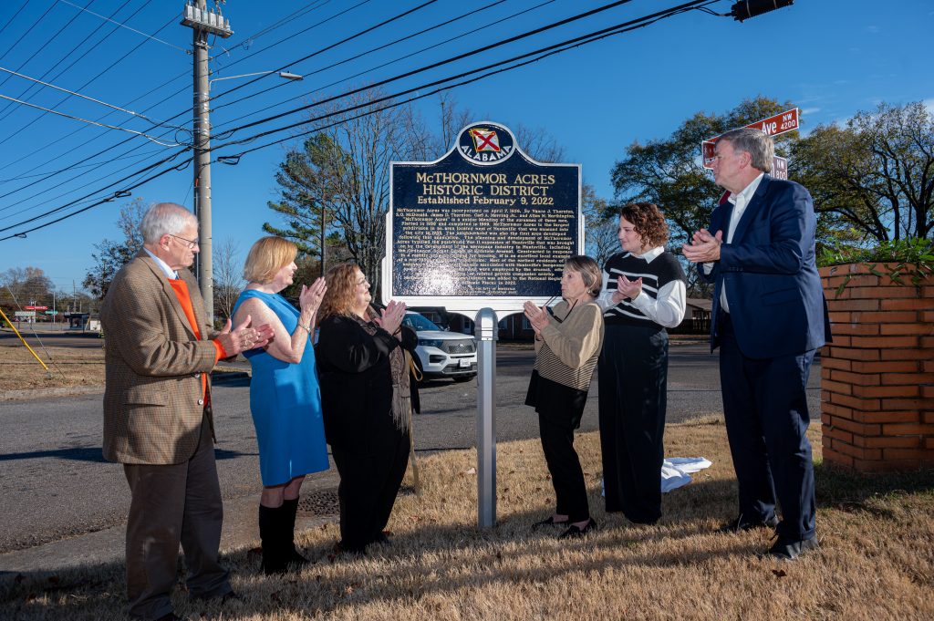 City representatives applaud the unveiling of a historic marker at the entrance of the McThornmor Acres neighborhood in Huntsville.