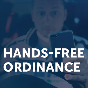 A graphic promoting the hands-free ordinance. There's a man in the background looking at his phone