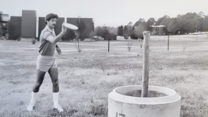 Tom Monroe plays frisbee golf in this undated black and white photo.