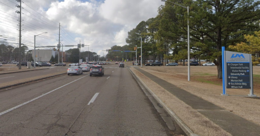 The Holmes Avenue corridor as soon from the campus of UAH. There are cars on the road and a traffic light in the background.