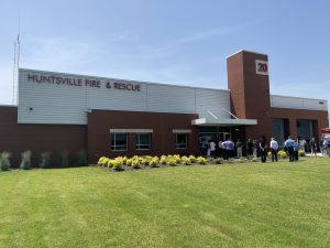 building with Huntsville Fire & Rescue on the front with green grass in foreground and blue sky above