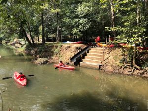 kayak launch point along small river with trees in background
