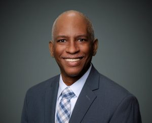 man smiling wearing coat and tie in portrait 