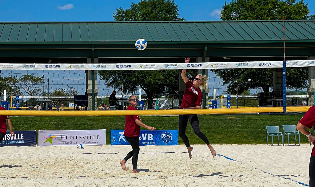 Volleyball players participate in a match at John Hunt Park. The open-air pavilion is seen at the rear.