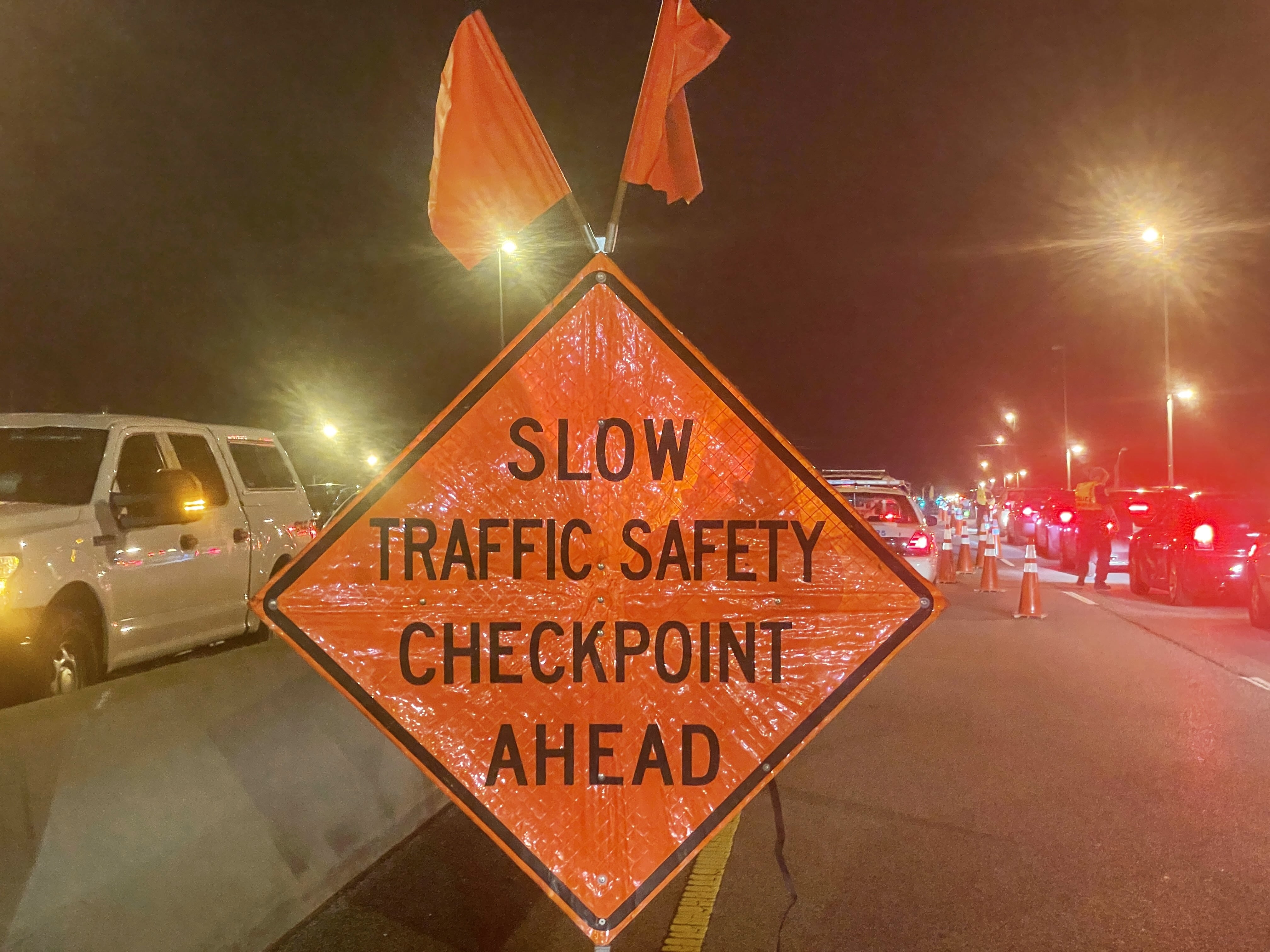 Photo of traffic sign that says 'SLOW TRAFFIC SAFETY CHECKPOINT AHEAD'