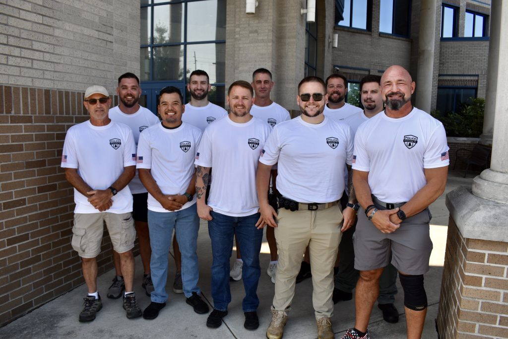 10 of the 15 officers with the Huntsville Police Department stand side-by-side, outside the Public Safety Complex, to pose for a photo as they get ready to head to Birmingham, Alabama for the 2025 World Police and Fire Games.