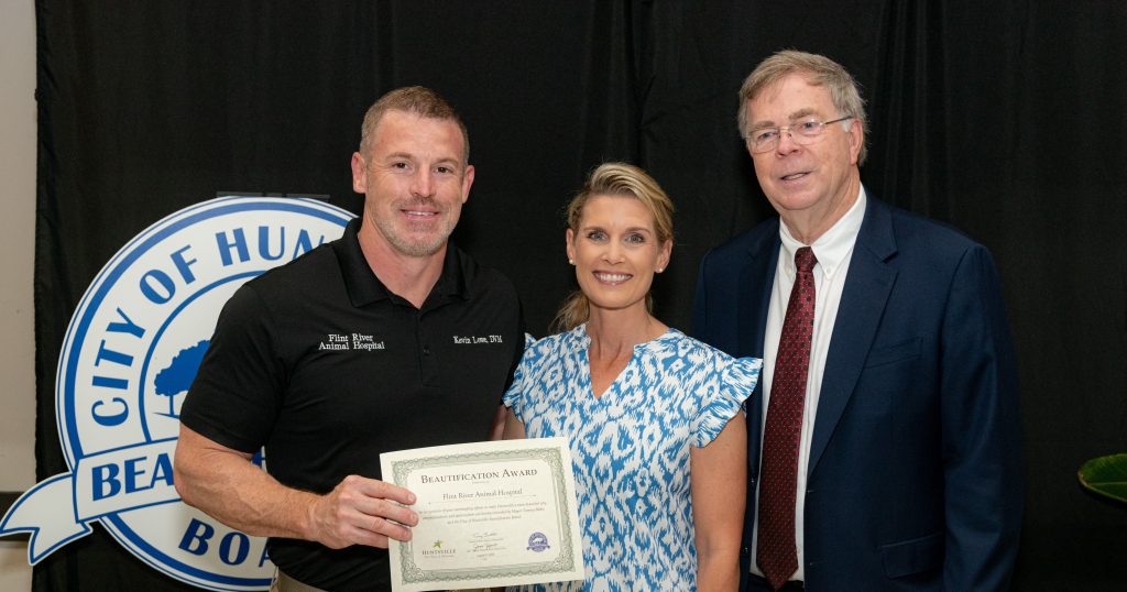 three people posing for photo at presentation