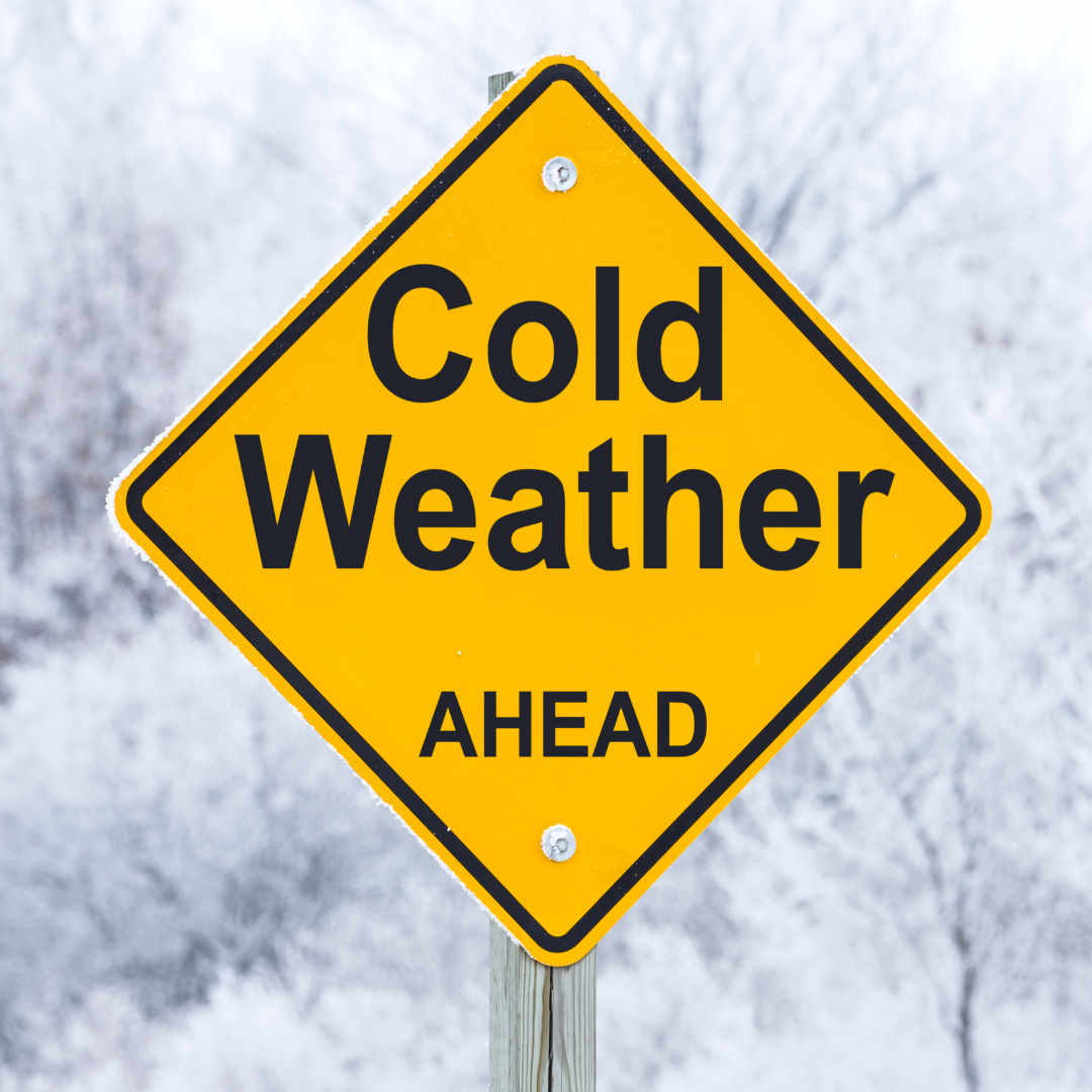 Yellow Cold Weather ahead road sign in front of snowy background