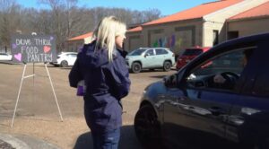 A woman from Huntsville Animal Services talks with a resident in a car during a community pet event
